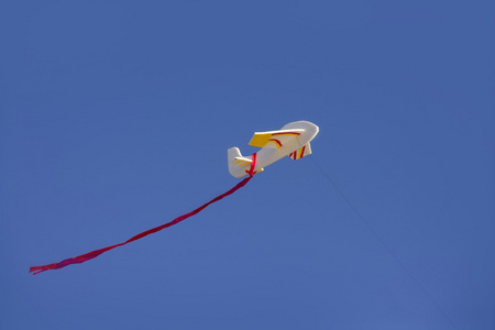 在阳光普照的蓝天上的飞机风筝