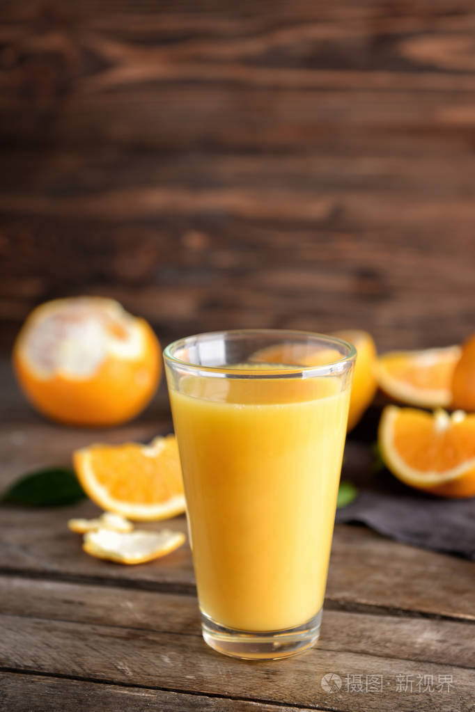 杯新鲜橙汁木制背景