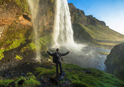 游客站在 Seljalandsfoss 在冰岛南部，Seljalandsfoss，冰岛最著名的瀑布之一