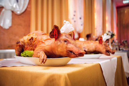 餐馆餐桌上的全烤猪照片