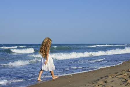 在蓝色的大海中运行海滩的小女孩