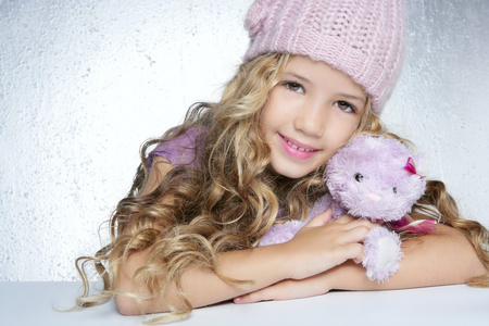 冬季时装帽小女孩拥抱泰迪熊微笑