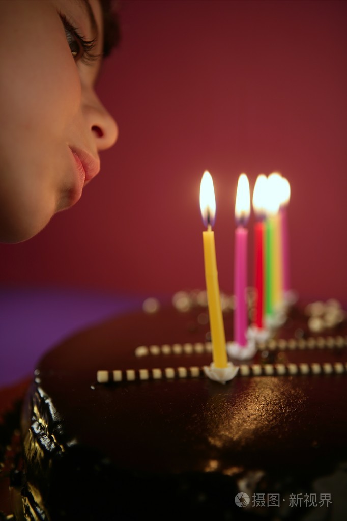 小女孩吹生日巧克力蛋糕蜡烛