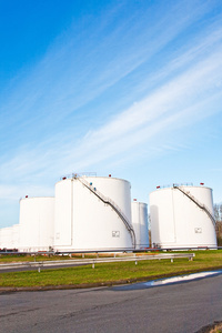 汽油和石油罐区与蓝蓝的天空中白色的坦克照片
