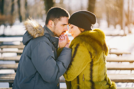 快乐的情侣在阳光明媚的冬日里漫步公园
