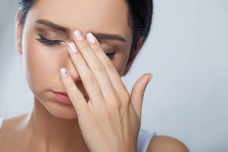 悲伤的年轻女子摸摸额头和感觉疼的强头照片