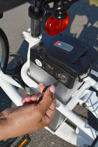 女骑自行车手抓住电的钥匙