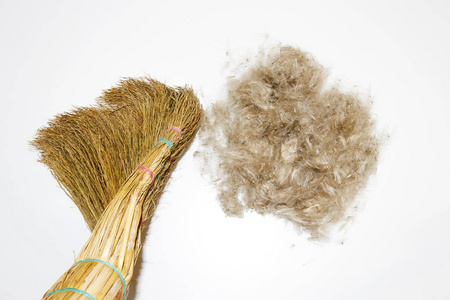 清洁概念。在白色背景的扫帚和羊毛球。扫你的头发