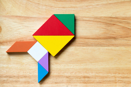 火箭导弹在木质背景下火箭或导弹形状的彩色七巧板拼图照片