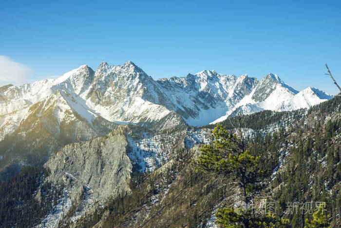 在日出的雪中, 贝加尔湖山脉的山峰的美丽景色.旅行和徒步旅行的概念