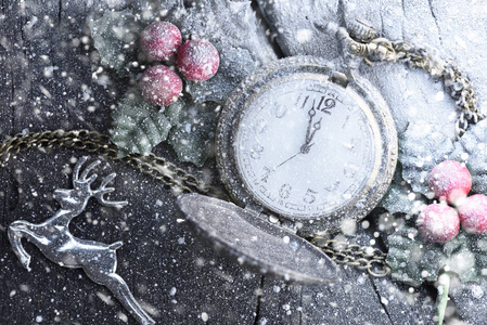 圣诞时钟带冬季装饰图案在雪地上。新年快乐概念