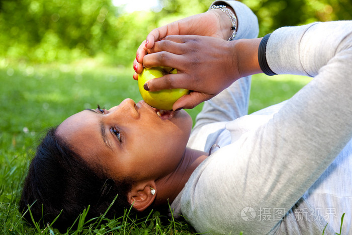 美丽的黑人女人吃苹果