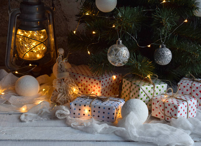 圣诞节和新年节日庆典的概念背景。点燃的蜡烛, 圣诞树装饰, 木桌上的礼物