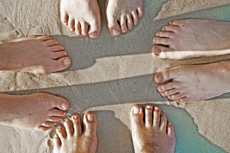 一家人的脚在细沙中被分成一个c