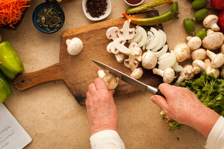 女人用厨房刀切片蘑菇