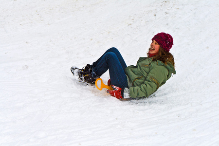 女孩在雪地上滑下山坡