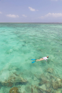 清晰的热带泻湖与绿松石蓝色水浅海浮潜的女人