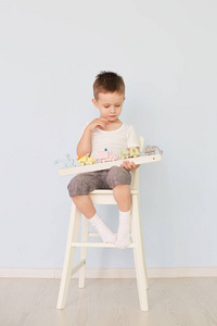 一个男孩玩机器, 坐在椅子上