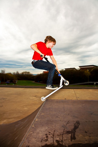 小男孩喜欢在溜冰场骑滑板车
