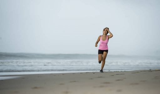 年轻有吸引力和适合亚洲体育赛跑者妇女奔跑在海滩海边微笑愉快在健身