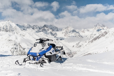 雪山背景下的现代蓝色雪地车