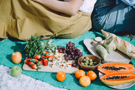 年轻妇女在夏季野餐时用健康食品放松身心