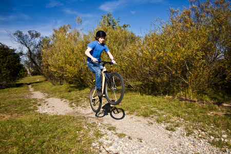 小男孩骑着土自行车，在风景优美的地方赛车