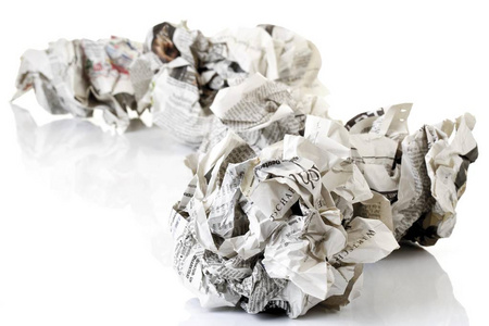 被弄皱的报纸在白色背景被隔绝了照片