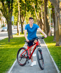 快乐年轻的白种人骑自行车在绿色自行车车道