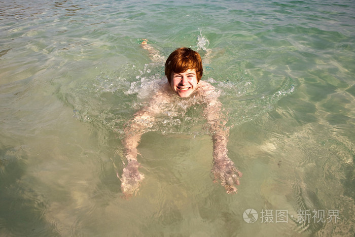 在美丽清澈的海洋里游泳的男孩