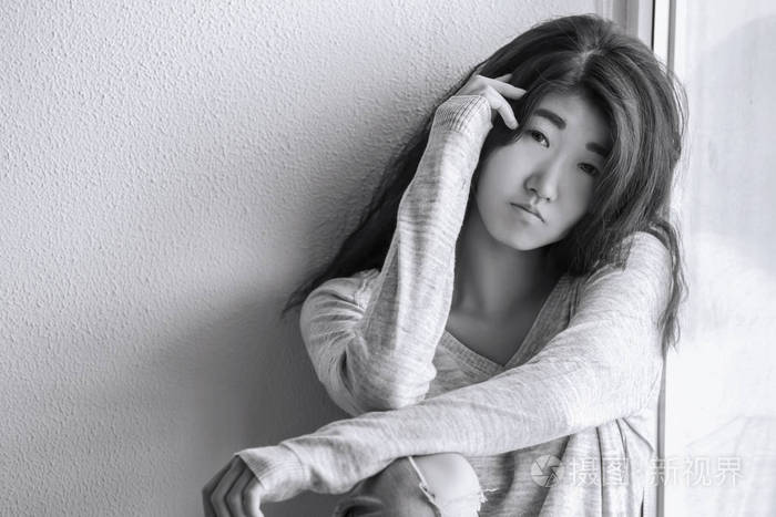 坐在窗口附近的哀伤的少妇