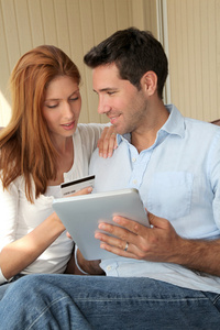 一对夫妇在网上购物，用电子平板电脑