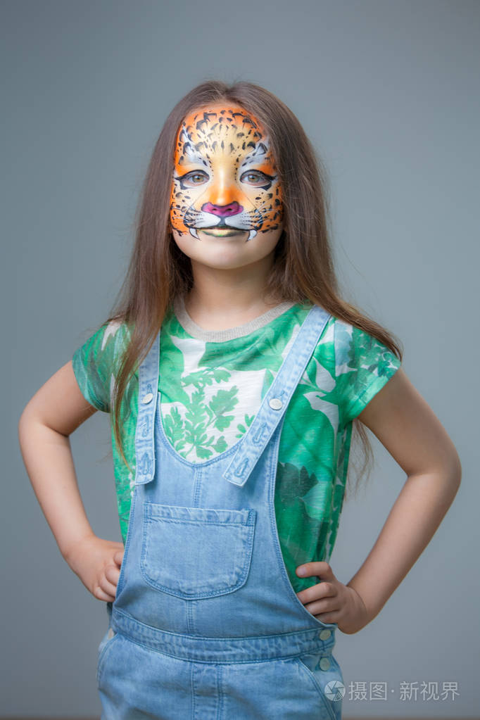 美丽的小女孩在她的脸上的水妆在老虎的形式