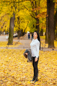 一个美丽的年轻女孩的肖像走在秋季公园