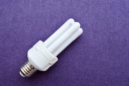 白色节能荧光灯灯泡四管, 在紫色布背景的银帽