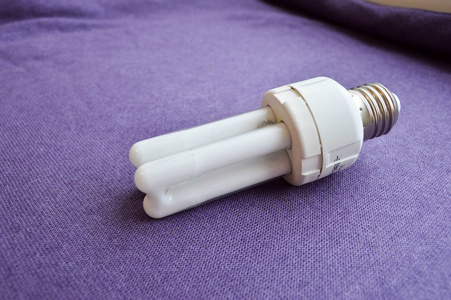 白色节能荧光灯灯泡四管, 在紫色布背景的银帽