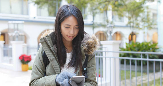 使用智能手机的妇女佩戴针织手套