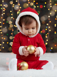 小男孩装扮成圣诞老人玩圣诞玩具, 深色背景照明, 新年快乐和寒假概念
