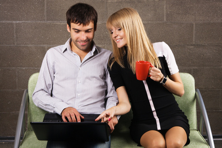 快乐的男人和女人用笔记本电脑工作