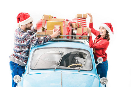 夫妇与圣诞节礼物在汽车屋顶图片