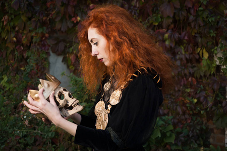 一只手拿着剑的中世纪女王和骷髅照片