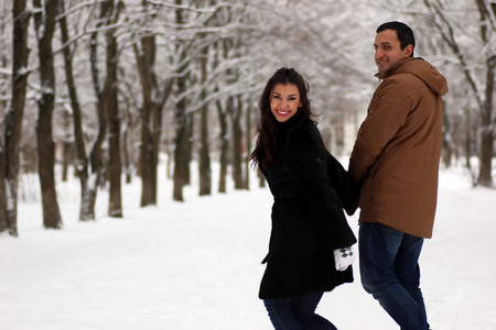 一对年轻夫妇在冬季公园散步