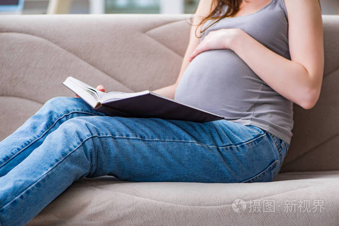 孕妇的肚子肚子坐在家里的沙发上