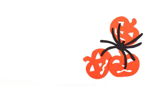 白色衬底上孤立的橙色南瓜和黑蜘蛛用黑纸雕刻的剪影