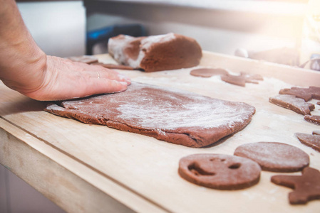 烤 gingerbreads这家人正在准备 gingerbreads。女人的手揉面团。准备圣诞节, 时间为家庭, 烹调和烘烤一起