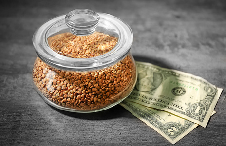 原料荞麦和桌上的钱。价格增长概念