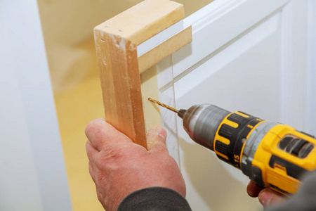 铰链开孔橱柜门上的家具铰链的安装在柜门上钻孔照片