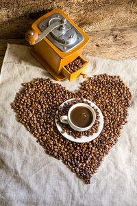 一杯热咖啡桌上。早晨喝咖啡。咖啡豆的组成。老式的咖啡研磨机