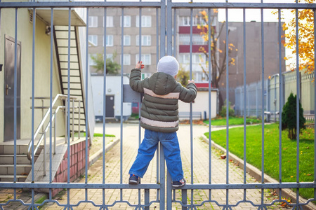 活跃的小男孩爬上围栏小男孩和女孩玩城市喷泉.活跃的户外休闲为孩子.