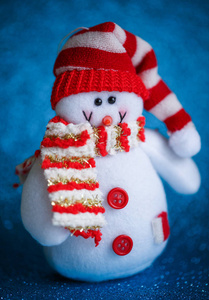 微笑雪人玩具穿着围巾和帽子上抽象的散景背景